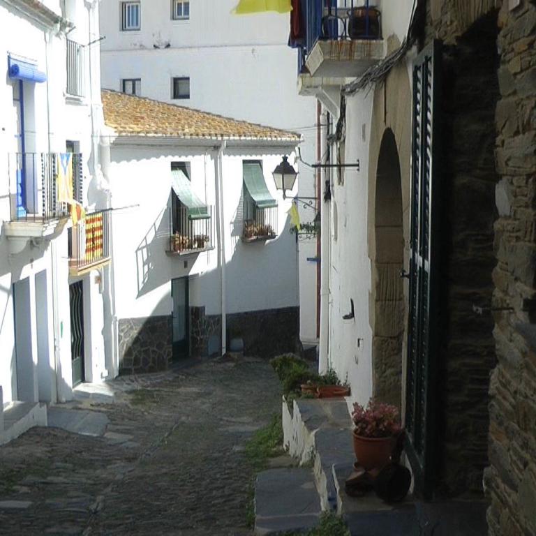 Eine enge, historische Gasse in einer Altstadt mit weißen Häuserfassaden und Kopfsteinpflaster.