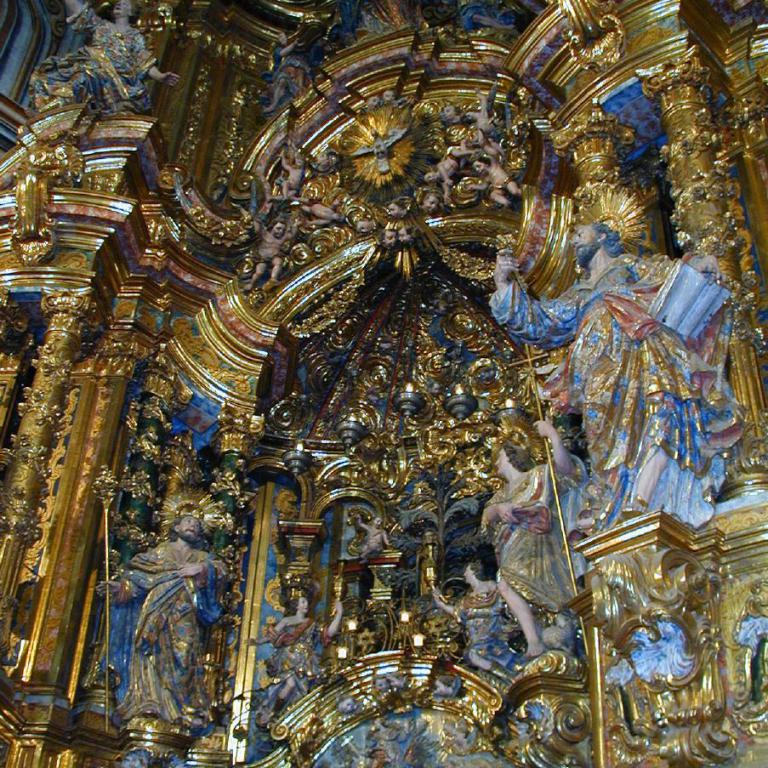 Überquellender goldener Kirchenaltar mit zahlreichen Statuen und Stuckverzierungen im Barockstil.