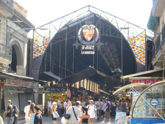 Der große, überdachte Markt La Boqueria, dessen imposantes Gewölbe die bunten Stände mit frischen Waren einrahmt.