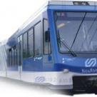 Die Frontansicht eines modernen, blauen Zugwagens mit großen Fenstern und einem aerodynamischen Design.